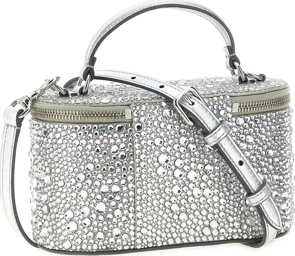 A silver rhinestone-embellished handbag with a top handle, adjustable shoulder strap, and zippered compartments, shown on a plain white background.