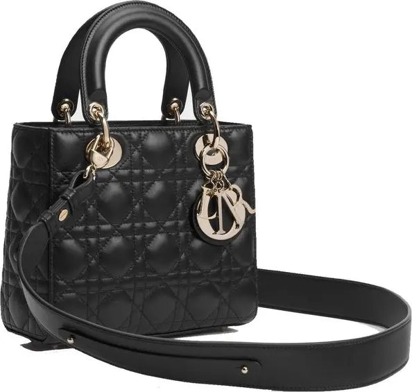A black quilted leather top-handle handbag with a detachable shoulder strap, gold-tone hardware, and a hanging Christian Dior CD charm, shown on a plain white background.