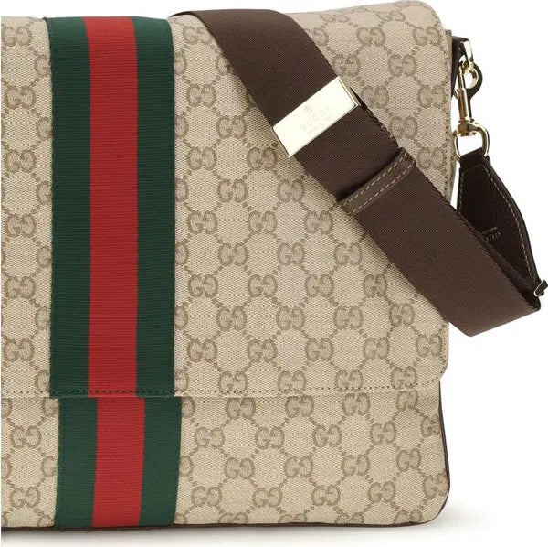 Gucci monogram canvas shoulder bag with a brown leather strap and signature green and red web stripe on a white background.
