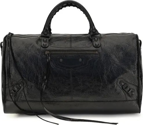 A black distressed leather duffle bag with top handles, a front zip pocket, and a shoulder strap, photographed against a plain white background.