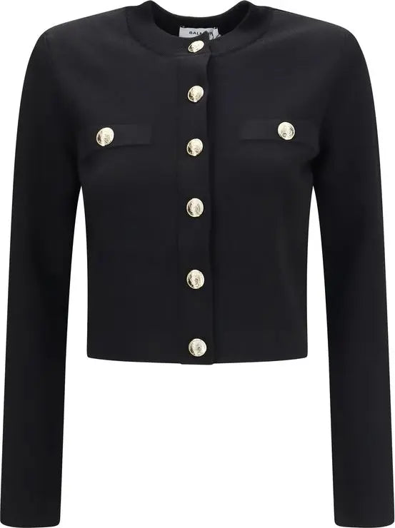 A black cropped jacket with long sleeves, a round neckline, and decorative gold-tone buttons on the front and chest pockets, shown against a plain white background.