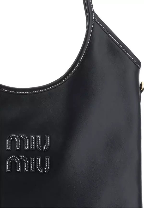 Close-up of a black leather shoulder bag with white contrast stitching and a white embroidered Miu Miu logo on the front, set against a plain white background.