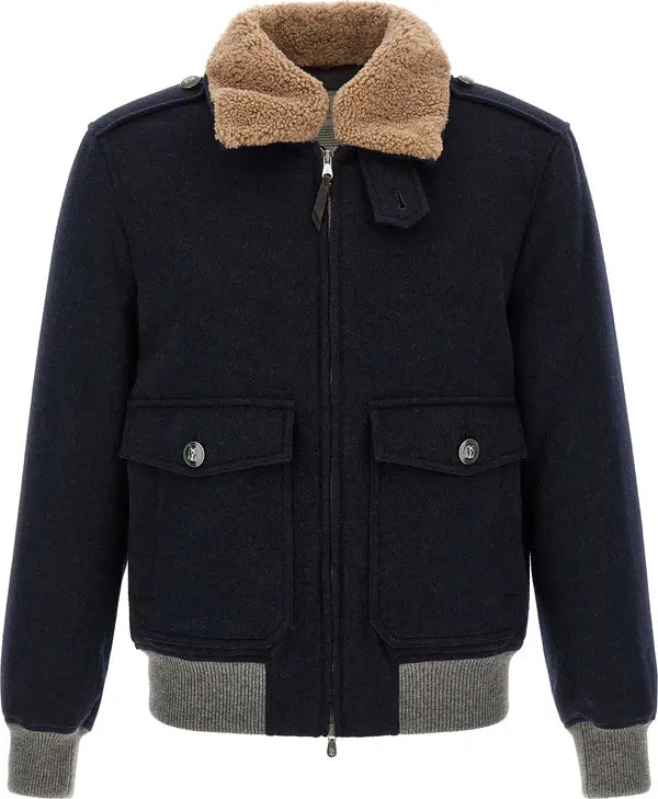 A dark navy wool jacket with a tan sherpa collar, gray ribbed knit hem and cuffs, and silver snap-button flap pockets.