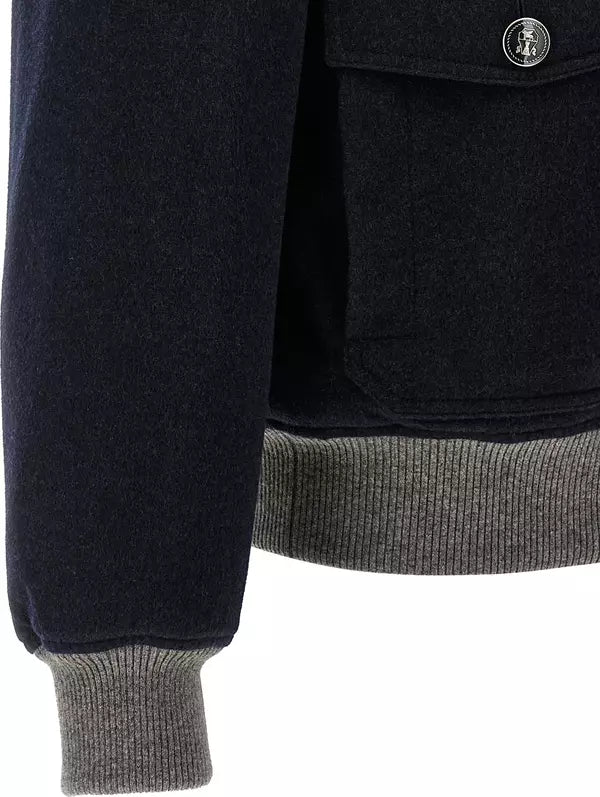 Close-up of a dark navy jacket with a gray ribbed hem and cuffs, featuring a buttoned chest pocket.