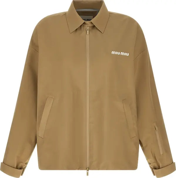 A tan Miu Miu zip-up jacket with a pointed collar, featuring the brand name &