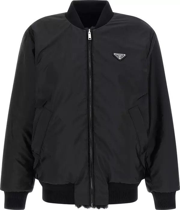 A black Prada nylon bomber jacket with a zip-up front, ribbed knit collar, cuffs, and hem, featuring the signature Prada triangle logo on the left chest.