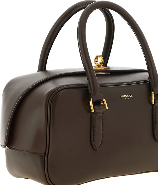 Balenciaga Bowling Le 7 small brown lamb leather handbag with aged gold-finish metal accents and embossed logo.