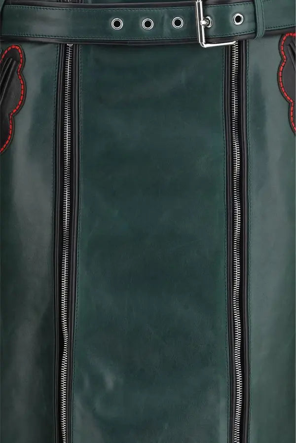 Close-up of a dark green leather belt with a silver buckle, showing the belt strap, eyelets, and zipper details on the sides.