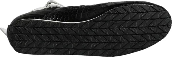 Close-up of a black shoe sole with white stitching on a gray background