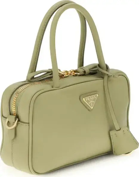 Green handbag with gold accents on a white background