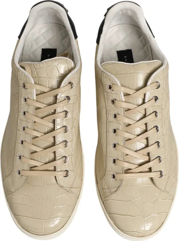 A pair of beige low-top sneakers with a glossy crocodile-embossed texture, shown from a top-down view on a white background.