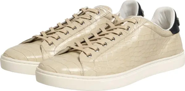 Beige crocodile-embossed leather low-top sneakers with matching laces and white soles, shown on a plain white background.