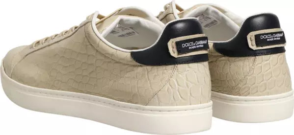 A pair of Dolce &amp; Gabbana low-top sneakers in beige textured leather with black heel tabs and white soles, shown on a plain white background.