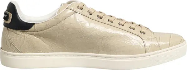 A beige crocodile-embossed leather sneaker with a black heel tab and a white sole, shown in a side profile view on a white background.