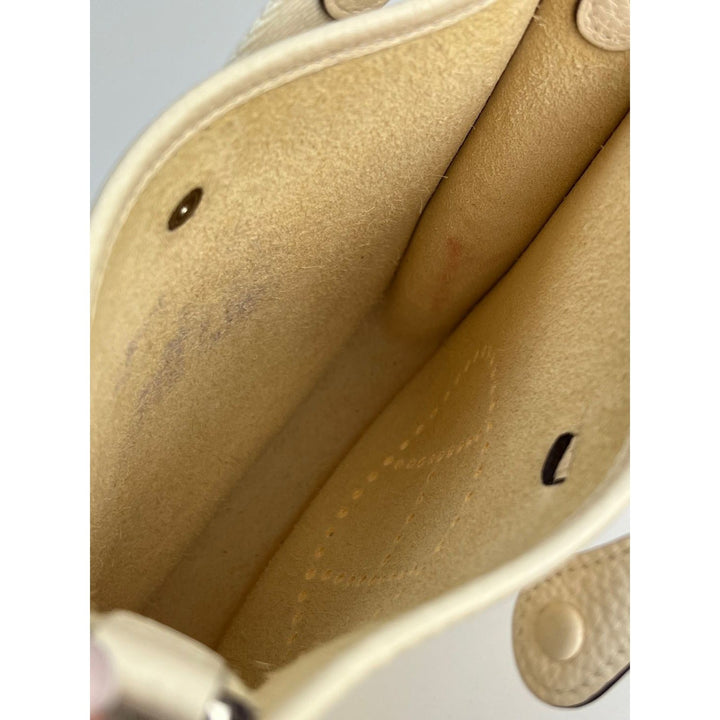 Close-up of a beige leather bag with visible stitching and hardware.