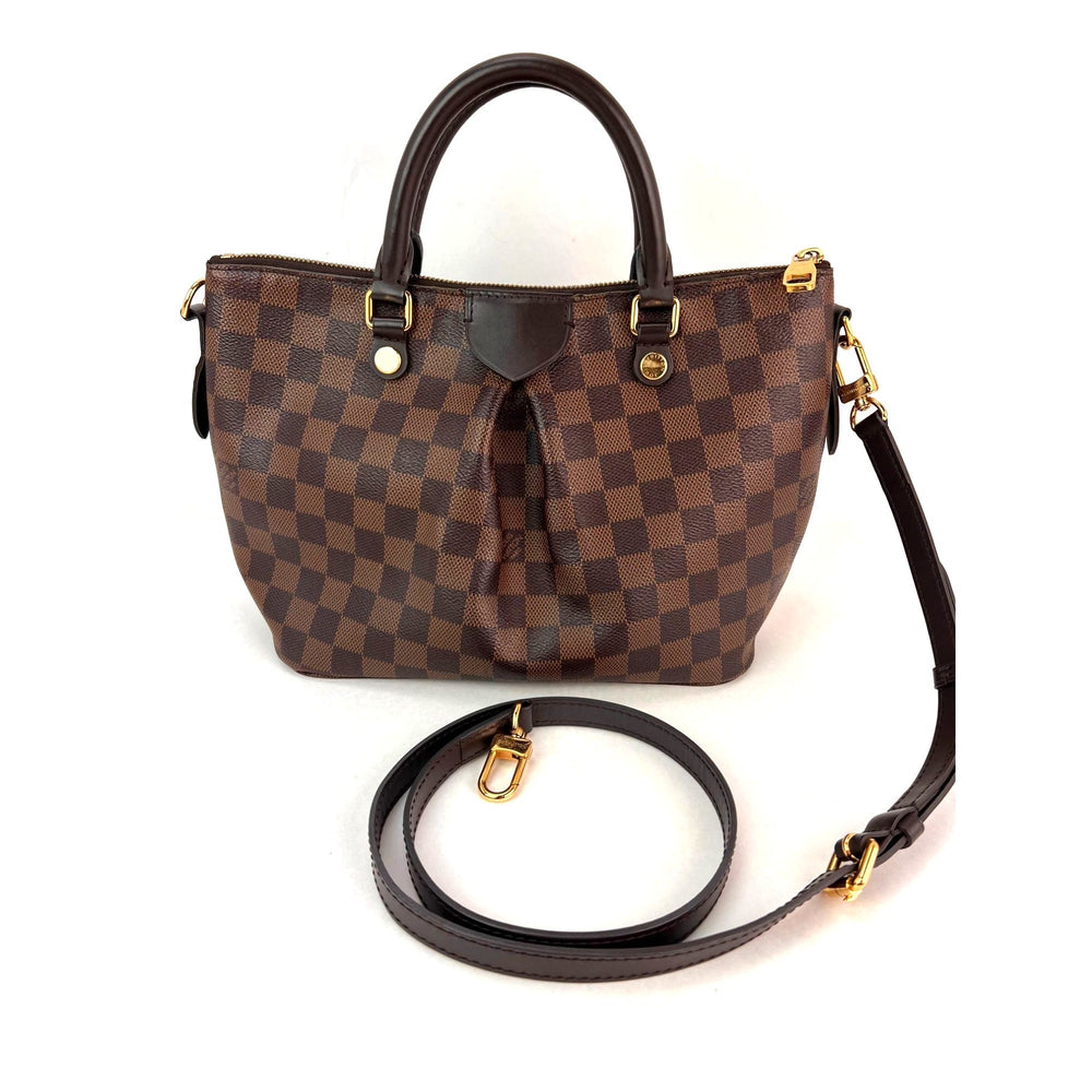 Brown checkered handbag with a detachable strap on a white background