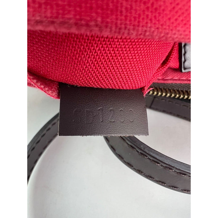 Close-up of a red bag with a visible brand label on a white background