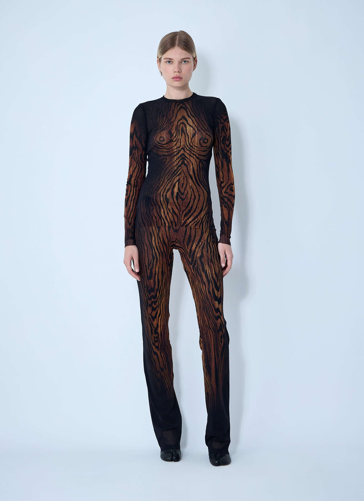 Model wearing a black and brown patterned outfit on a white background