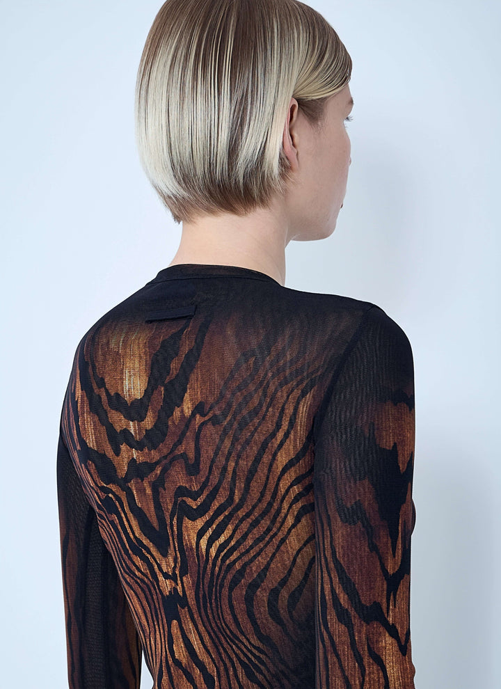 Person wearing a black and brown patterned garment against a white background