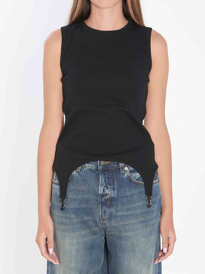 Person wearing a black sleeveless top and blue jeans on a white background