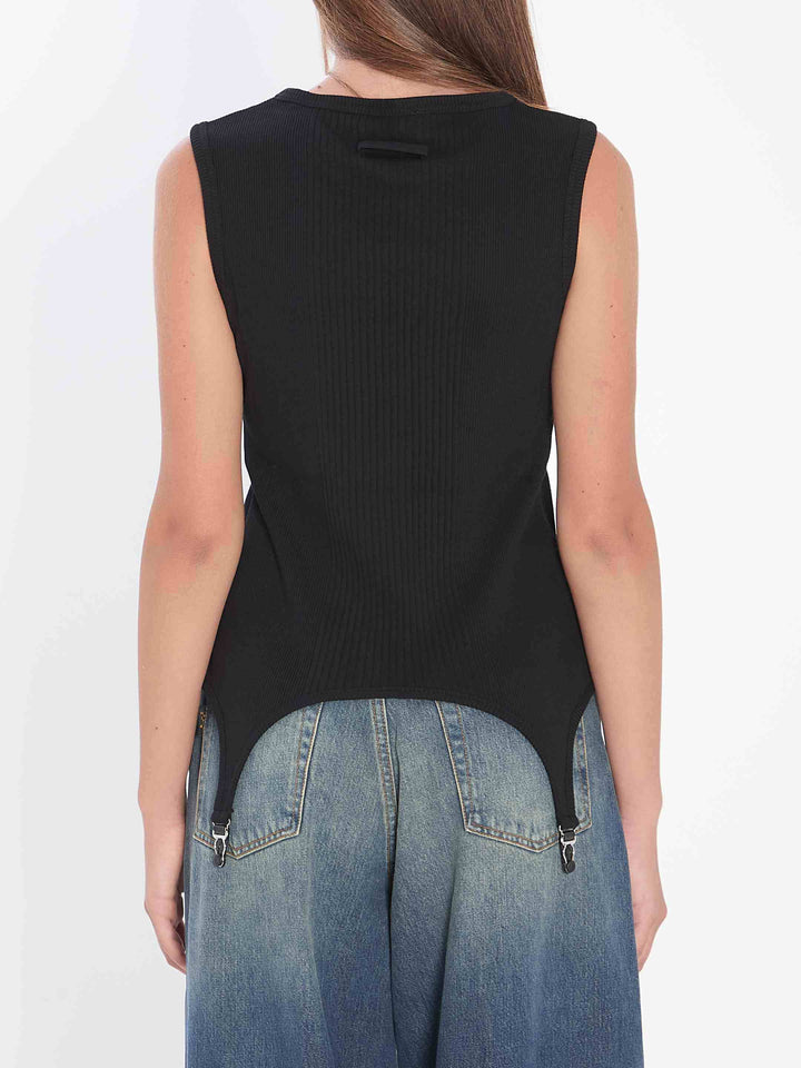 Person wearing a black sleeveless top and blue jeans on a white background
