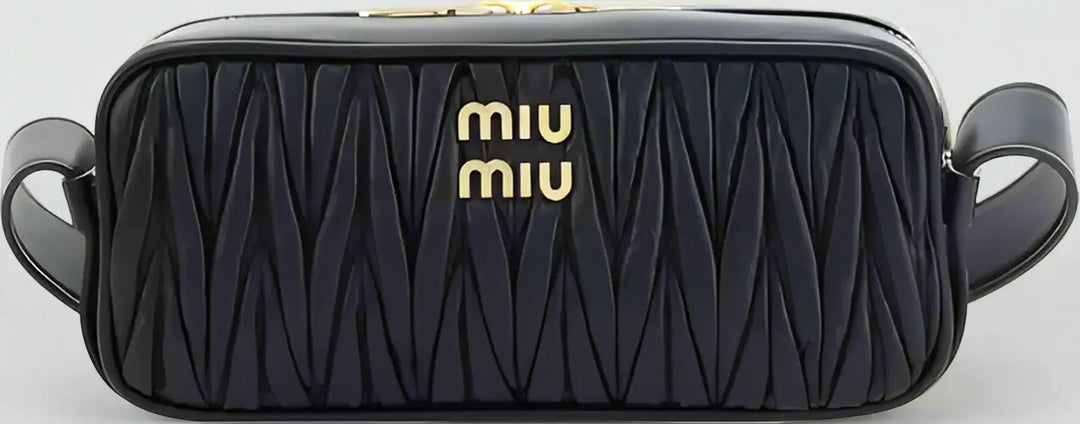 Black quilted handbag with gold 'miu miu' logo on a white background