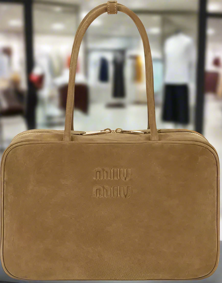 Brown leather bag with 'Milly' branding on a white background