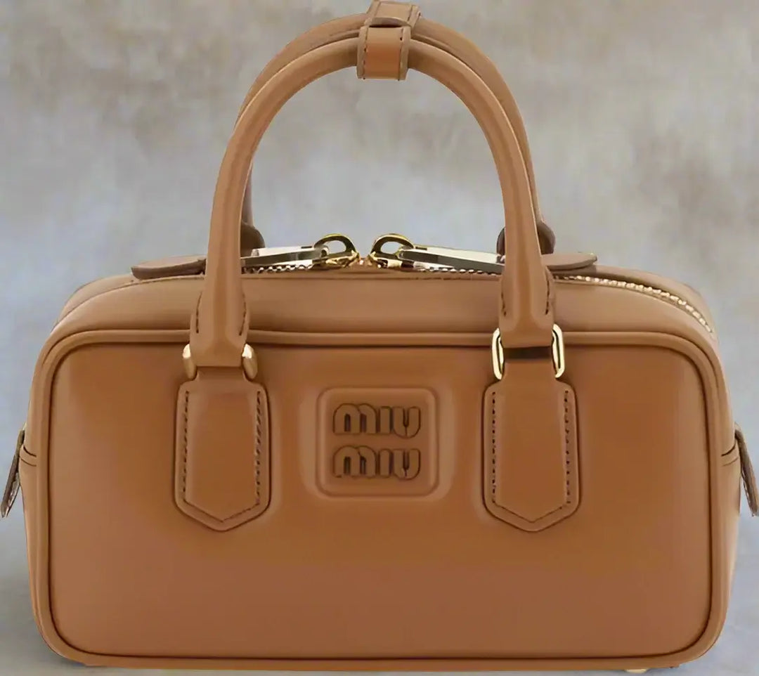 Brown handbag with gold accents on a white background