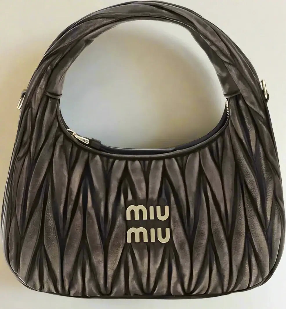 Brown textured handbag with 'Miu Miu' logo on a white background