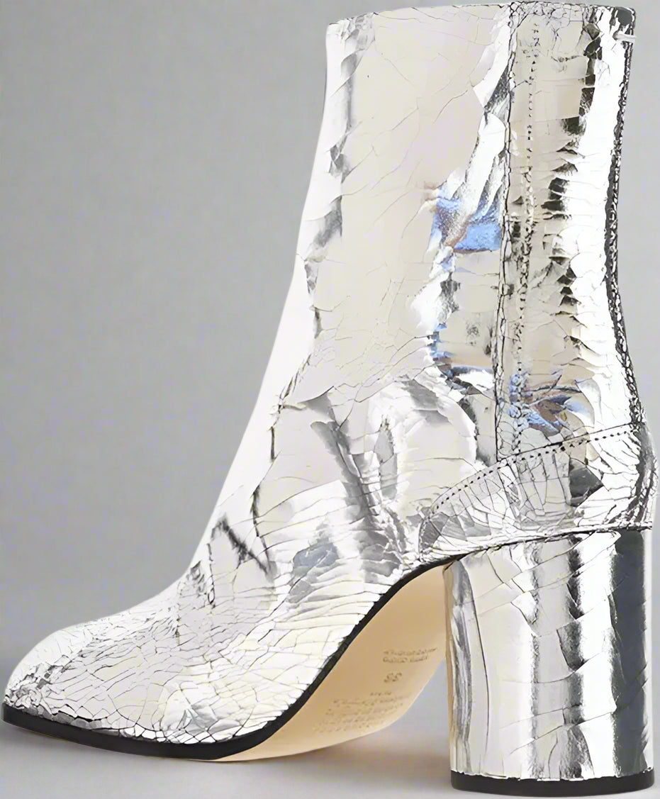 Silver metallic ankle boot with block heel on a white background