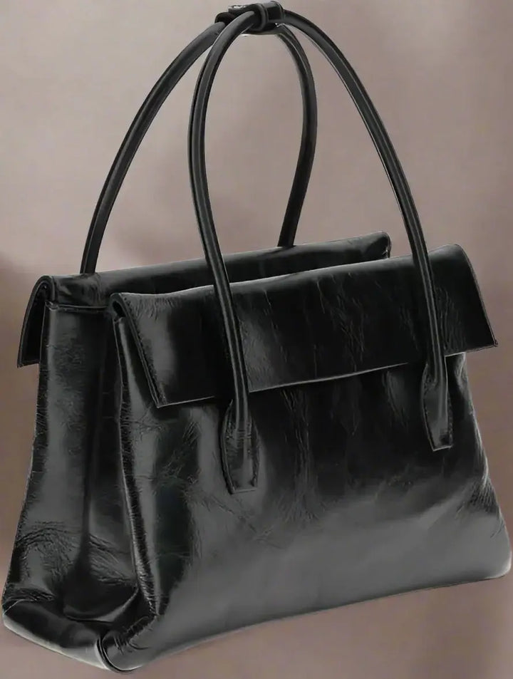 Black leather handbag with handles on a white background