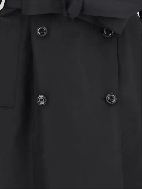 Close-up of a black coat with buttons on a plain background