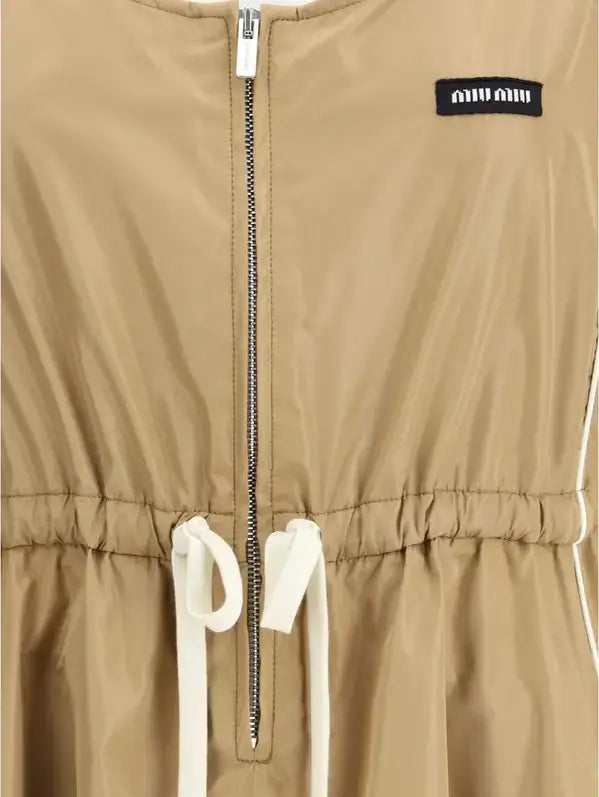 Beige jacket with a zipper and drawstrings, featuring a brand logo on the chest.