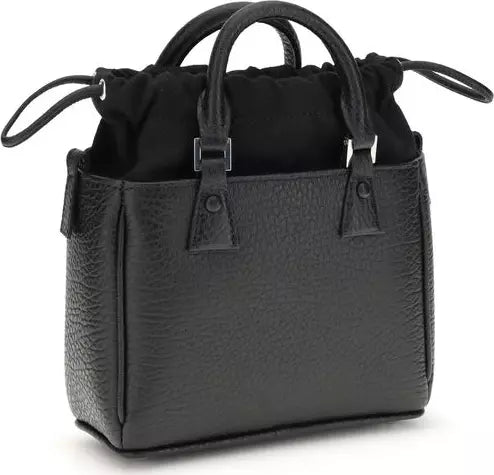 Black handbag with textured surface and drawstring on a white background