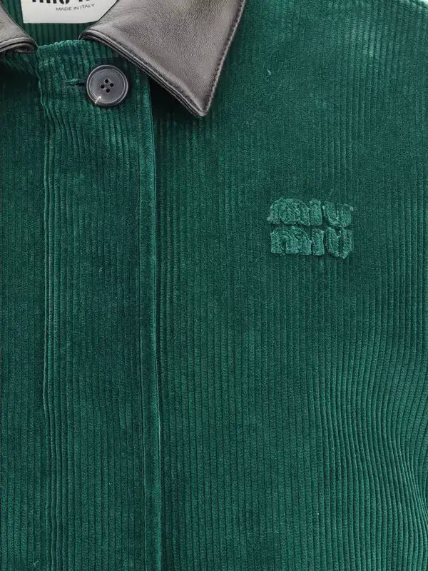 Green corduroy jacket with a brand logo on a close-up view