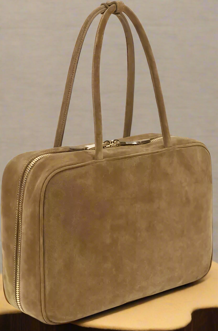 Brown leather handbag with a handle on a white background