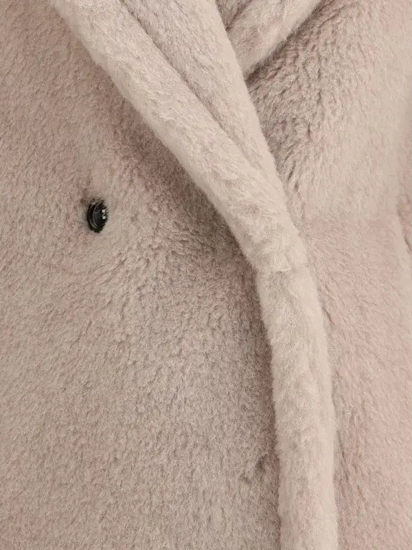 Close-up of a textured beige fabric with a button and white cord.