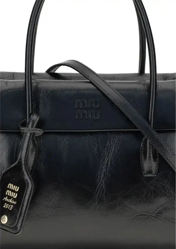 Black leather handbag with visible brand logo and tag on a white background