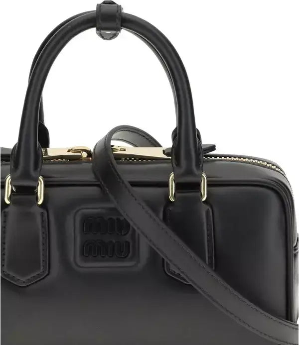 Black handbag with gold accents on a white background