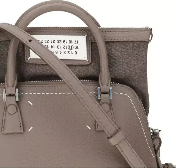 Brown handbag with visible brand label on a white background