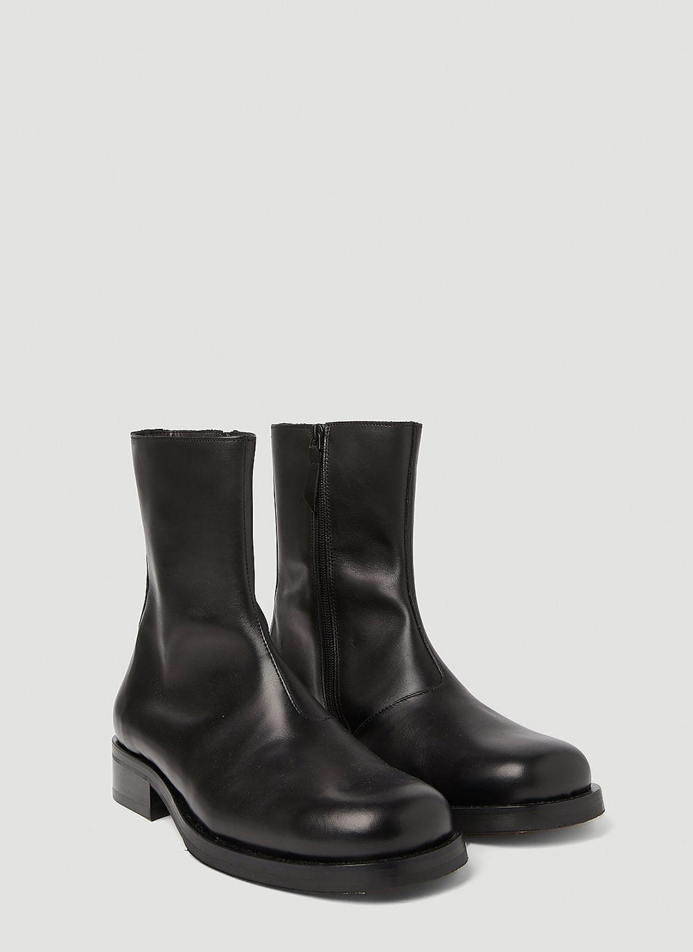 Pair of black leather ankle boots on a light gray background