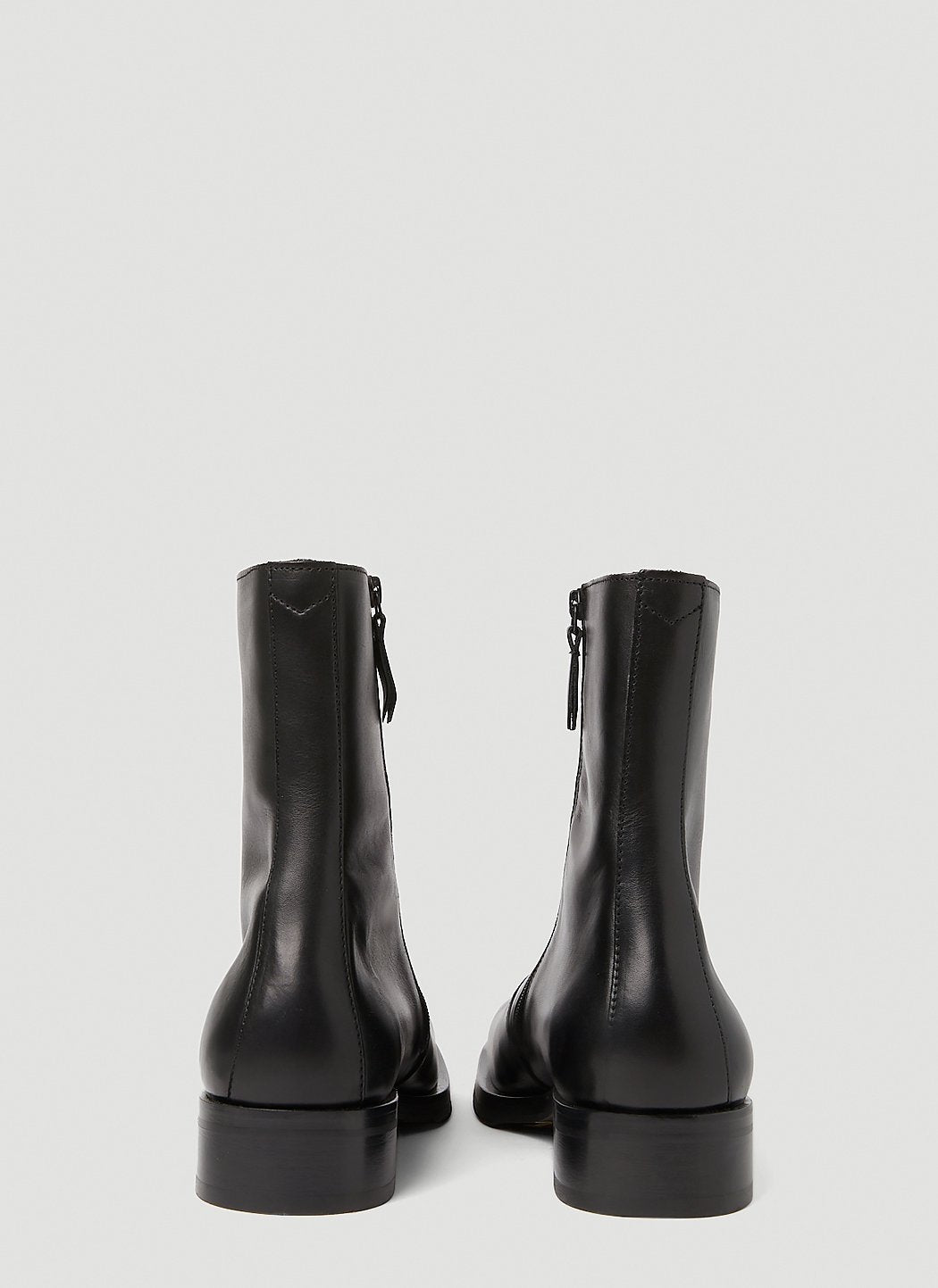 Black leather boots on a light gray background