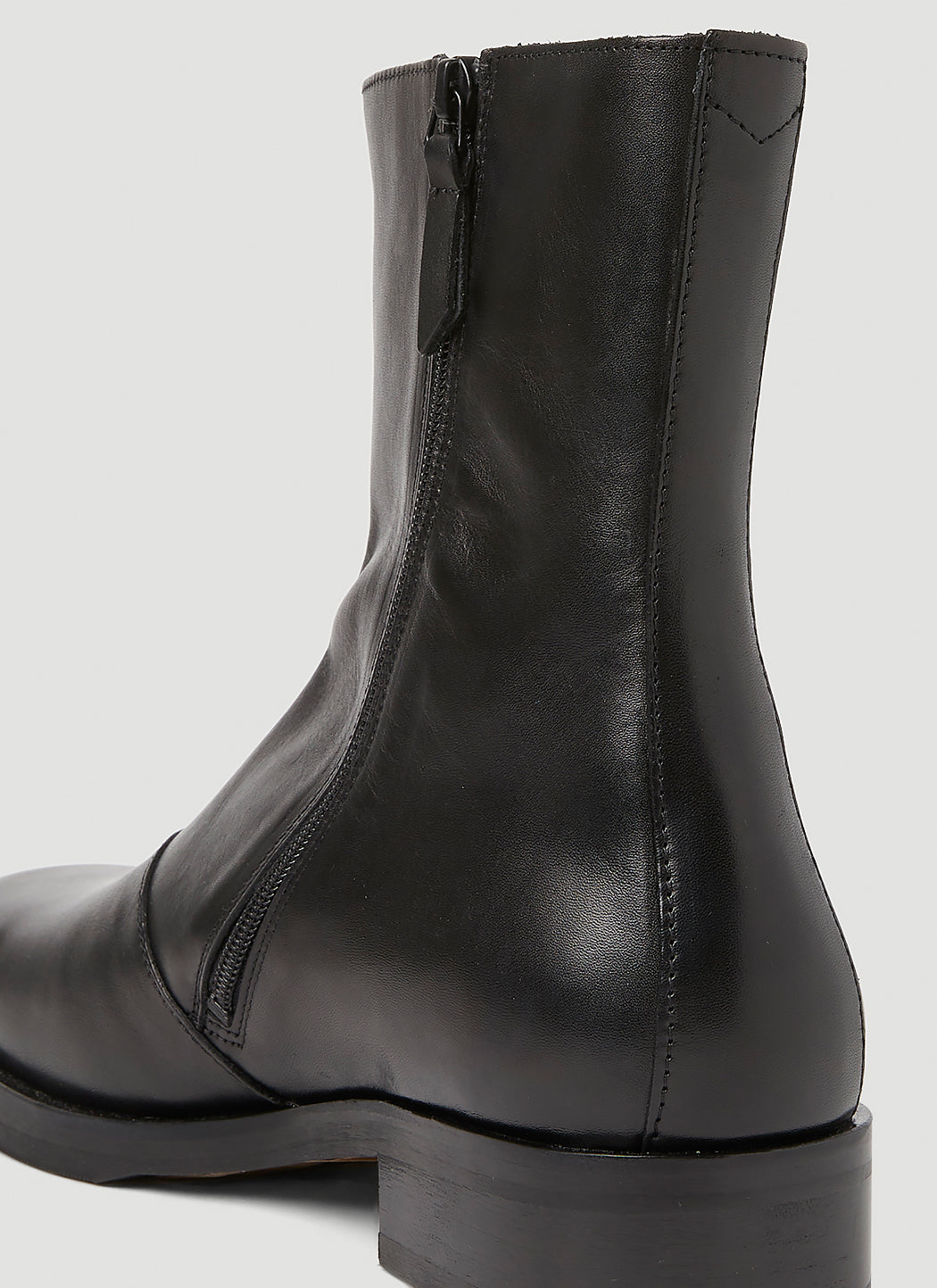 Black leather boot on a light gray background