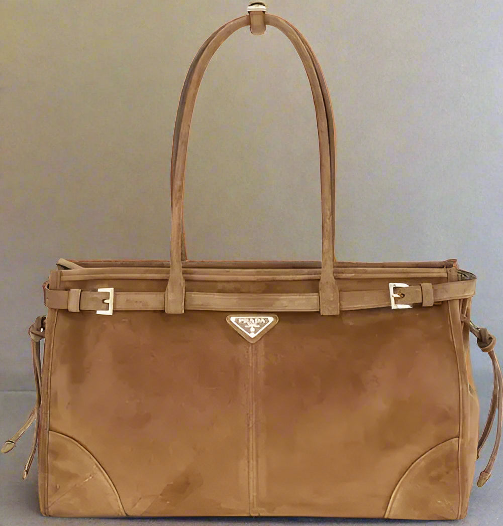 Brown leather handbag with a visible brand logo on a white background