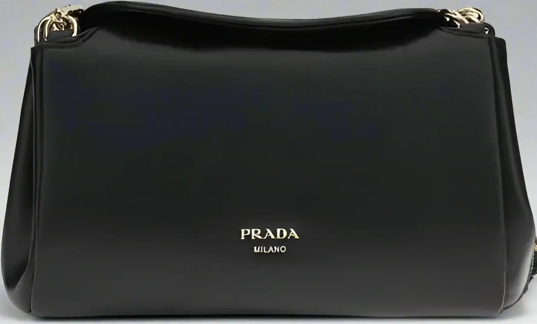 Black Prada handbag with gold accents on a white background