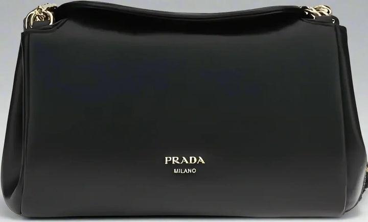 Black Prada handbag with gold accents on a white background