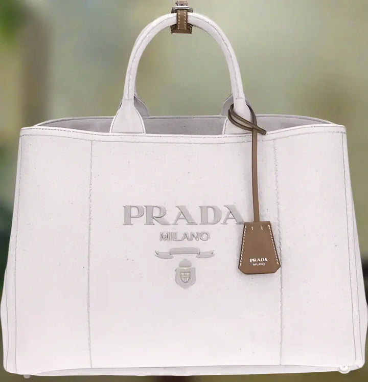 White Prada handbag with a brown tag on a white background