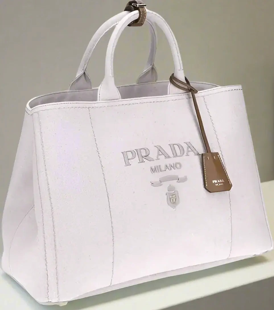 White Prada handbag with logo and tag on a white background