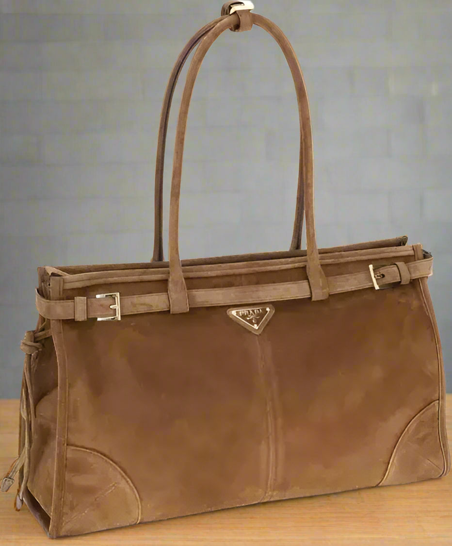 Brown leather handbag with Prada logo on a white background