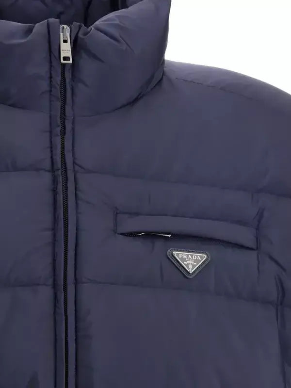 Navy blue puffer jacket with Prada logo on a white background